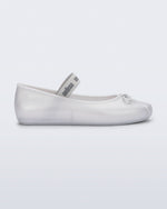Side view of a pearly white Sophie flat with top elastic strap and small bow
