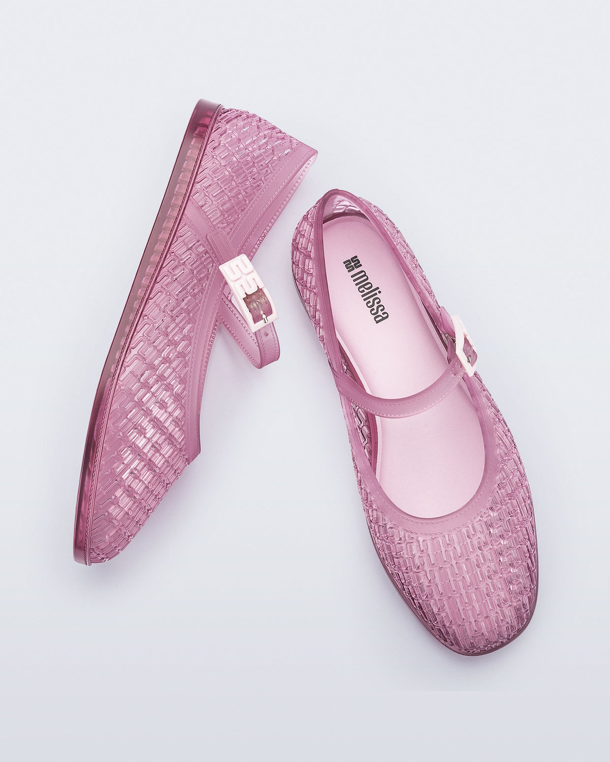 Top and side view of a pair of clear pink Harper flat with strap