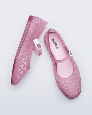 Top and side view of a pair of clear pink Harper flat with strap
