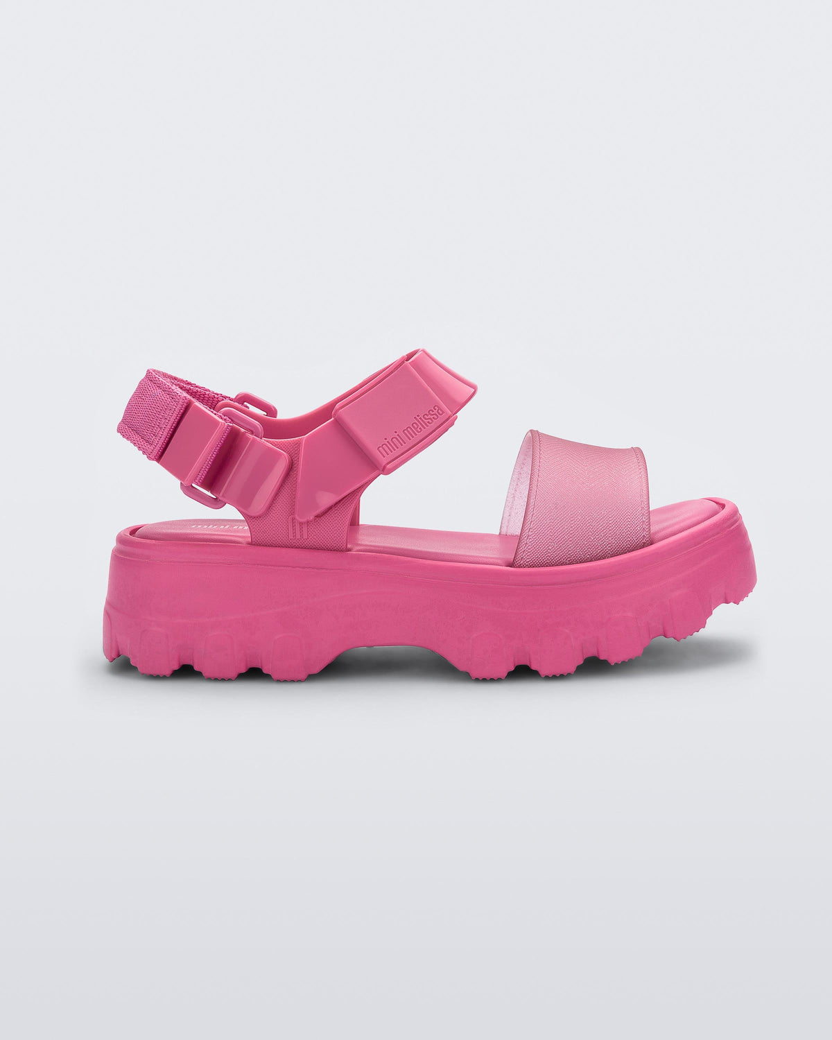 Side view of a Mini Melissa Kick Off platform sandal in pink with adjustable velcro ankle strap.