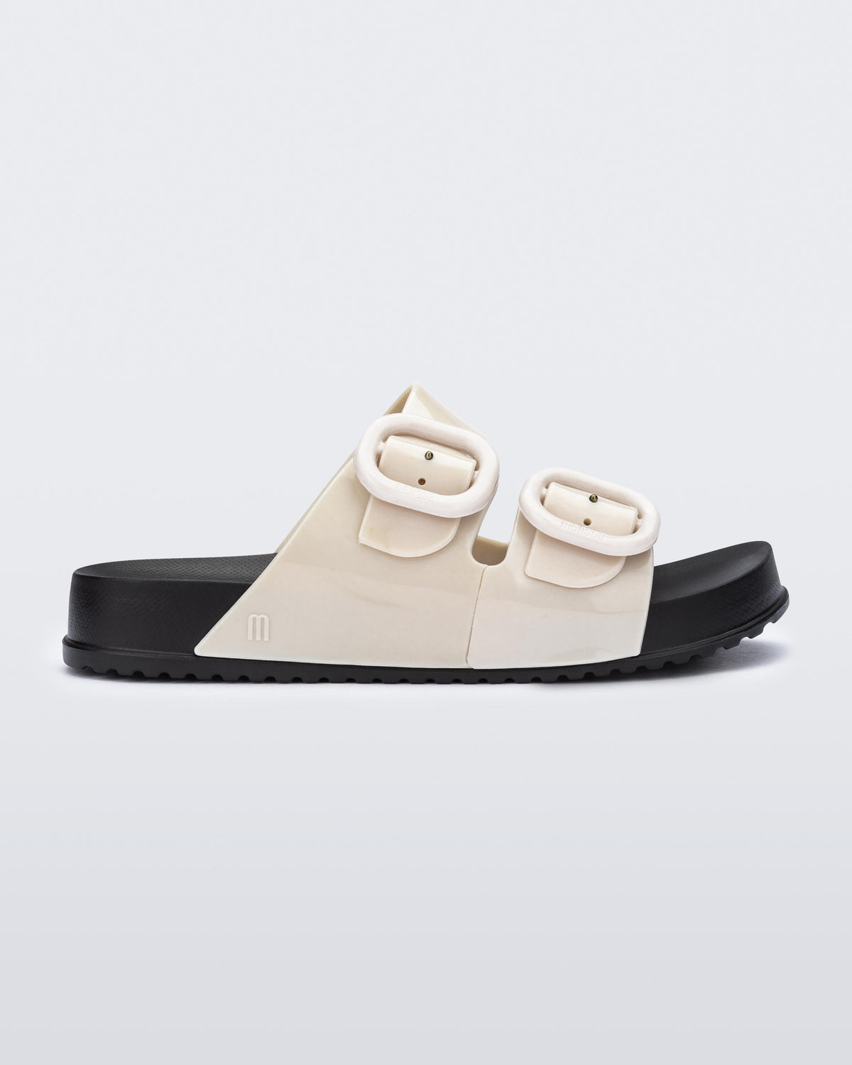 Side view of a kids beige Cozy slide with black sole