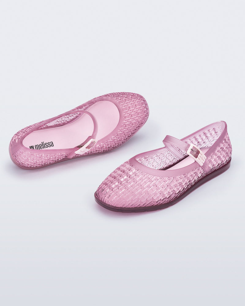 Top and angled view of a pair of clear pink Harper flat with strap