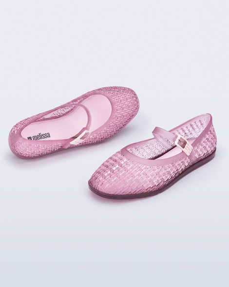 Top and angled view of a pair of clear pink Harper flat with strap