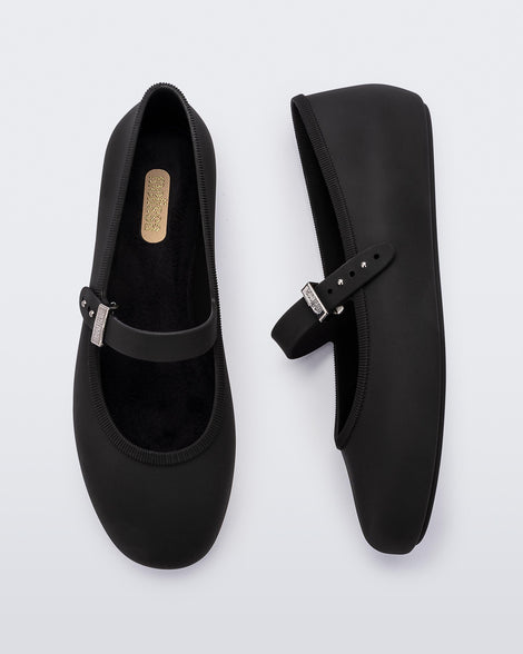 Top and side view of a pair of black Soft adult flats with strap and silver buckle