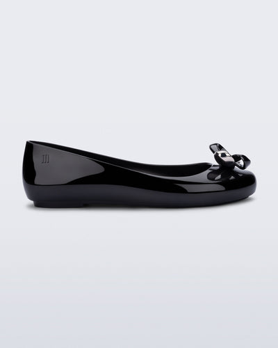 Side view of a black Sweet Love Glam ballerina flat with chrome bow