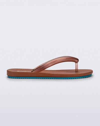 Side view of a brown Flip Flop Airflow sandal with a clear brown strap and blue bottom