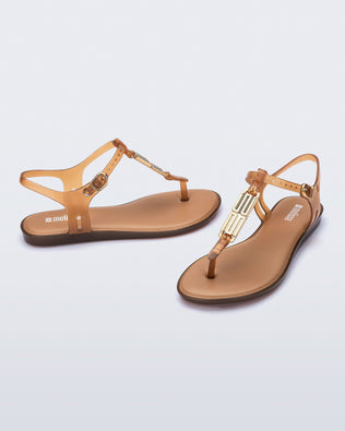 Side and front view of a pair of brown Solar M Chic sandals with gold embellishment
