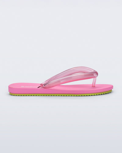 Side view of a pink Flip Flop Airflow sandal with a clear pink strap and green bottom