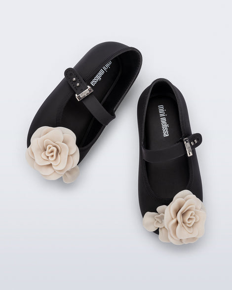 Top view of a pair of black Soft Ballerina baby flats with beige flowers