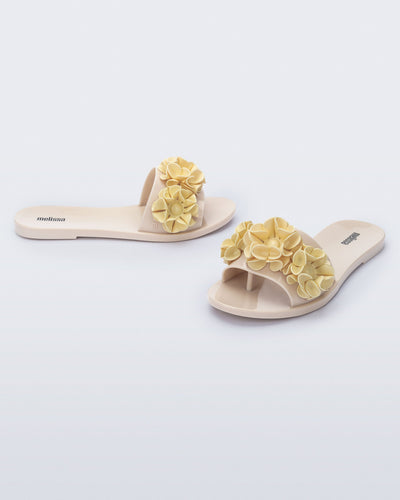 Angled view of a pair of beige Babe Springtime slides.