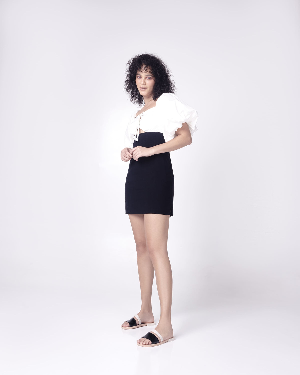Model in a black and white dress wearing a pair of  black and beige Ivy women's slide