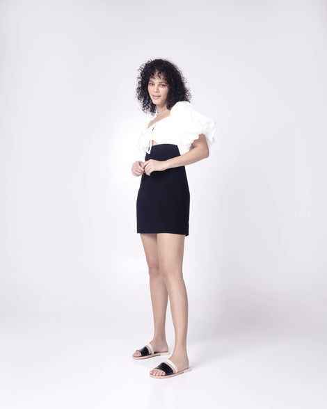 Model in a black and white dress wearing a pair of  black and beige Ivy women's slide