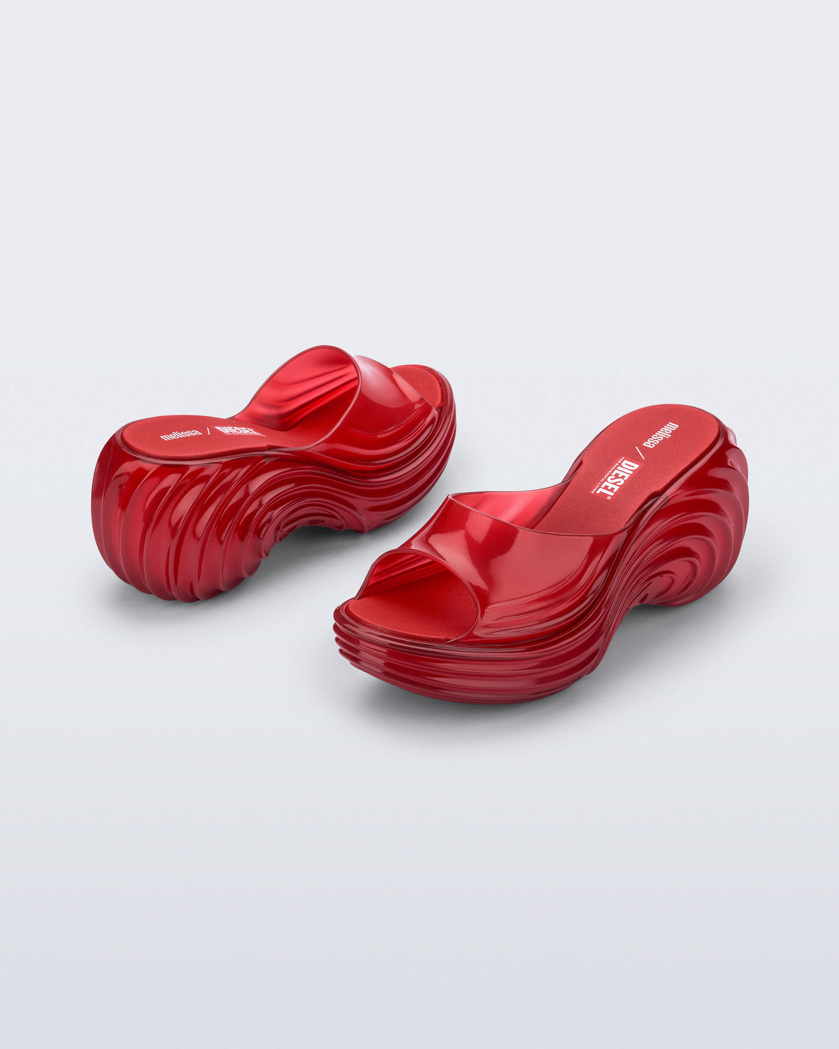 Back and side view of a pair of transparent red Platforms + Diesel slides