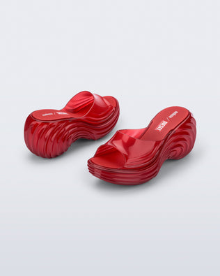 Back and side view of a pair of transparent red Platforms + Diesel slides