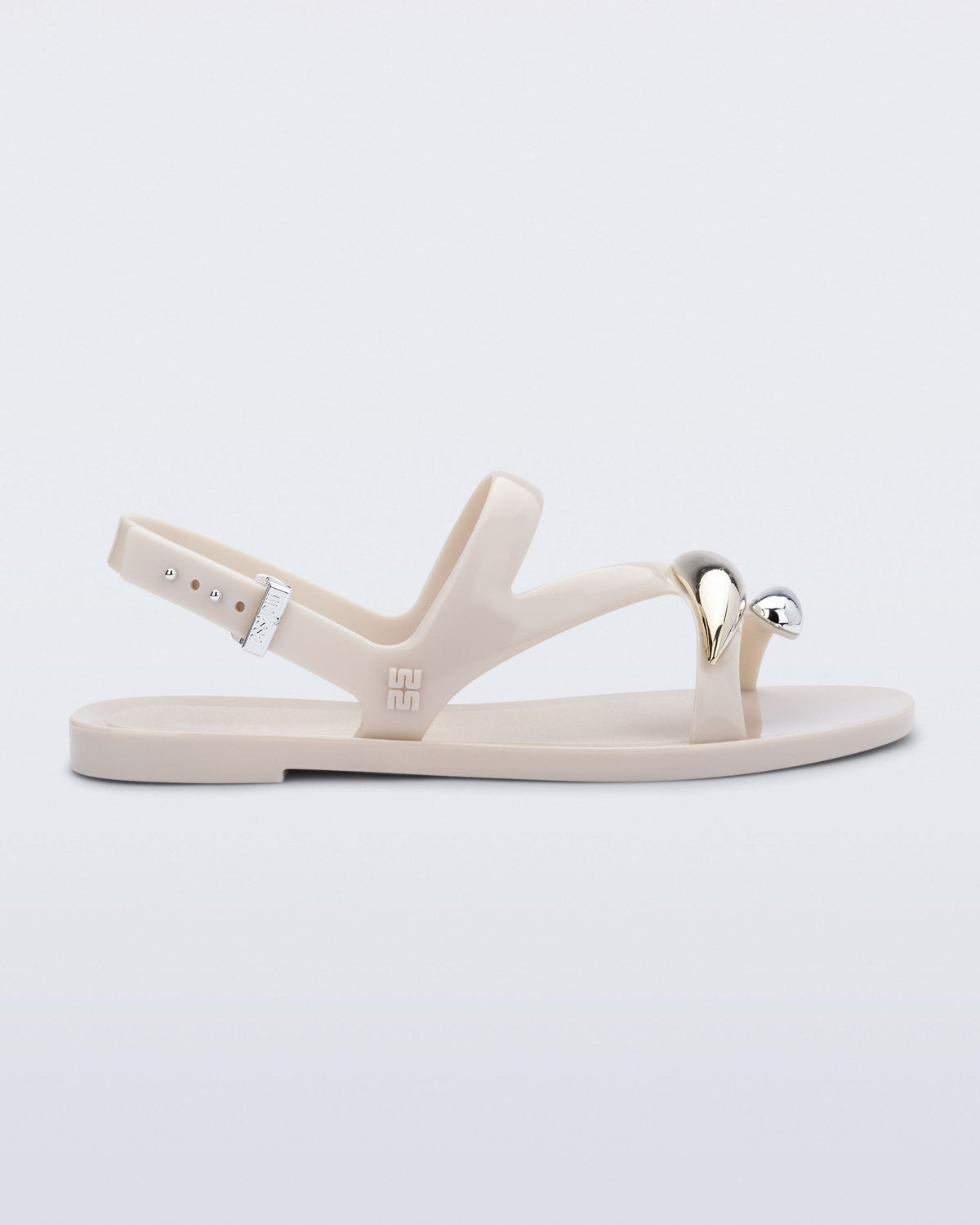 Side view of an beige  Iris sandal with gold upper embellishments