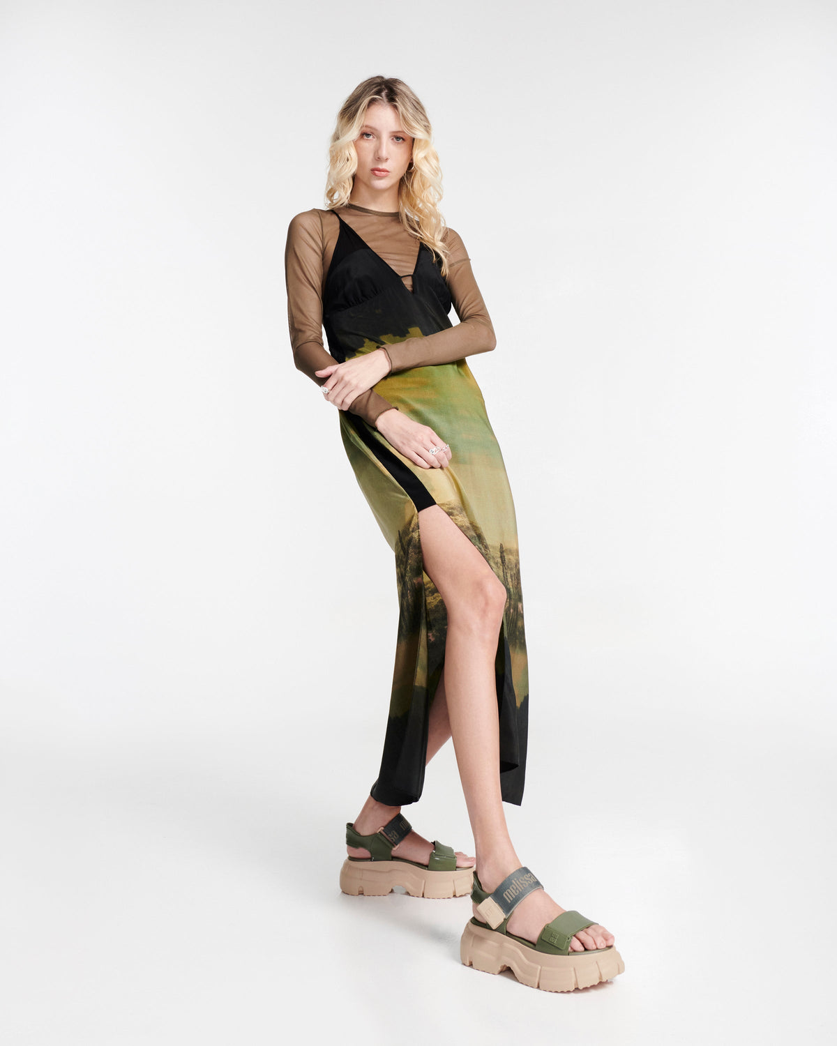 Model in a dress wearing a pair green Pulse platform sandals with straps and pink sole