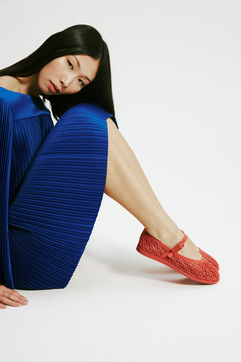 Model in a blue dress wearing a pair of red Harper ballet flats