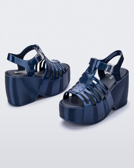 Back and side angled view of a pair of blue Station 79 platform heels with ankle straps