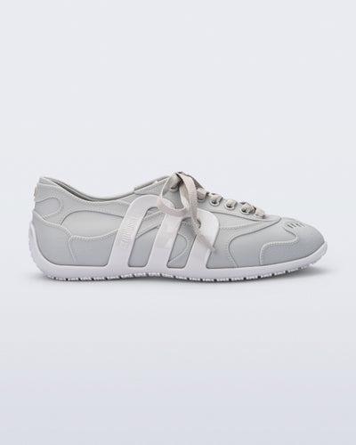 Side view of a grey Motion sneaker with white colored sole and M monogram