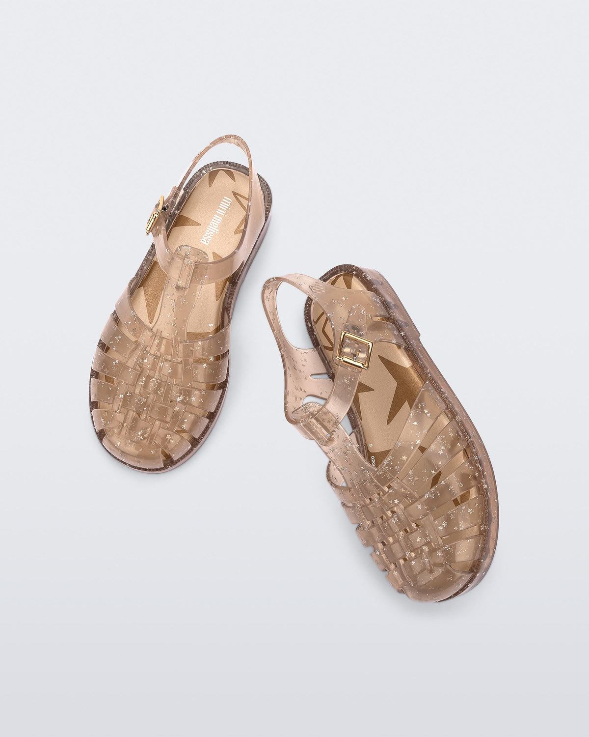 Angled and top view of a pair of clear beige Possession kids sandals with star glitter