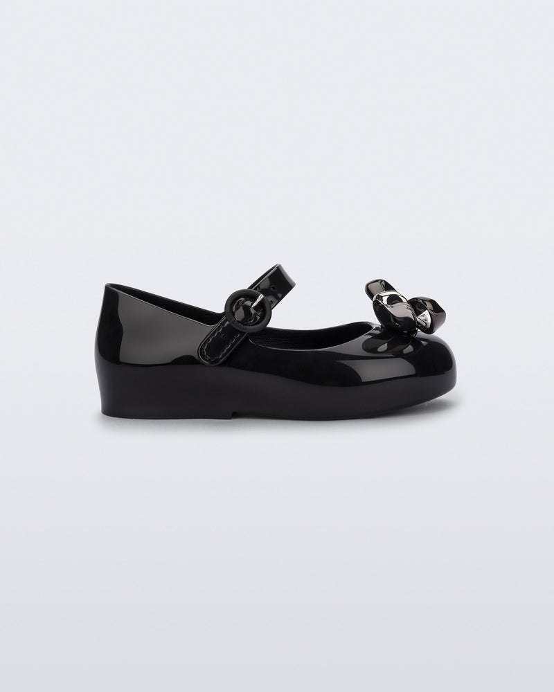 Side view of a black Sweet Love Glam baby ballerina with bow