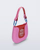 Angled view of a pink Nina Bag + Alexandre Pavao shoulder bag with red accents