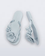 Top and side view of a pair of blue Harmonic Petals kids flip flops with flowers