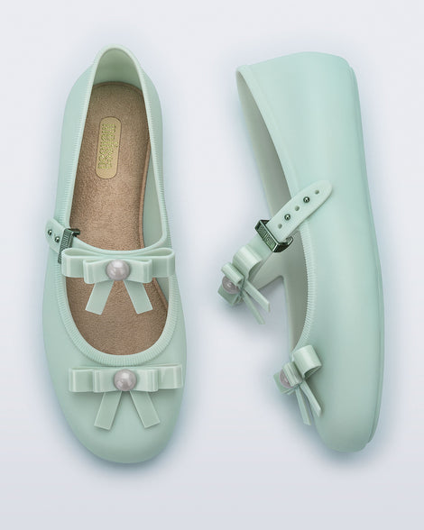 Top and side view of a pair of green Soft Ballerina Bow flats with bows and a pearl in the center of each bow