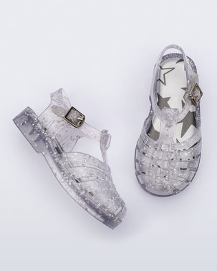 Side and top view of a pair of clear Possession baby sandals with star glitter