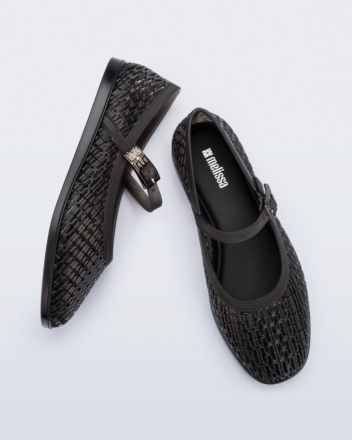 Top and side view of a pair of clear black Harper flat with strap
