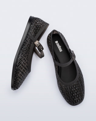 Top and side view of a pair of clear black Harper flat with strap