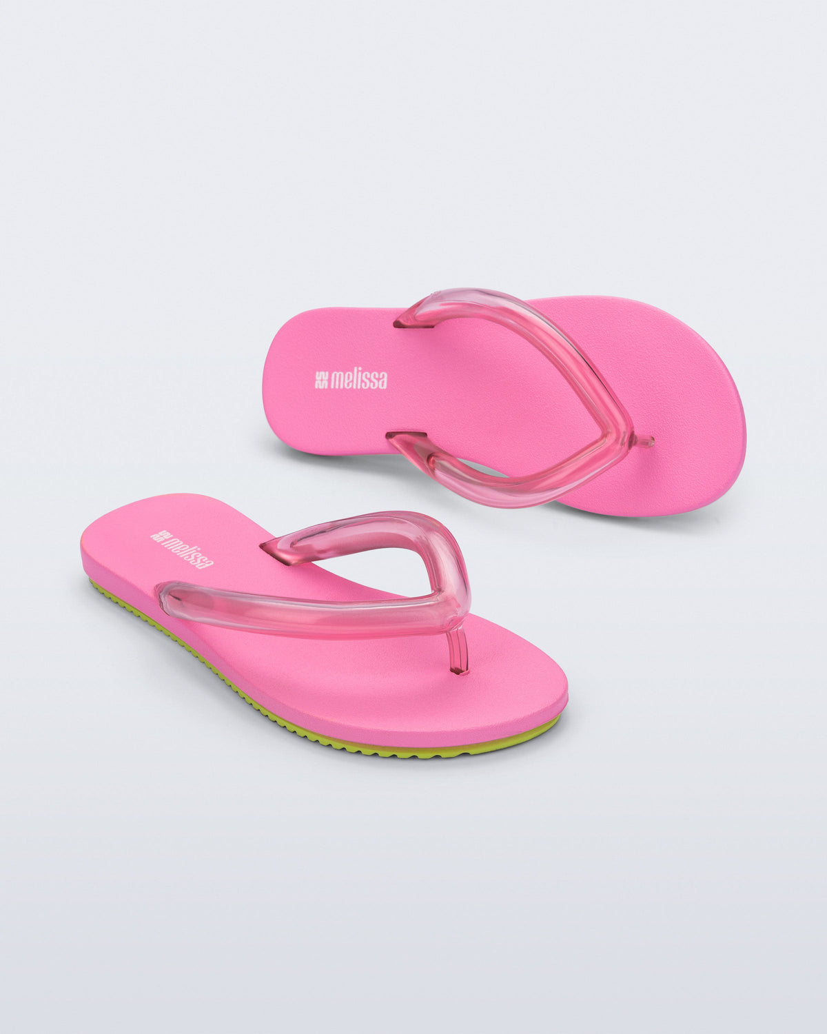 Top and angled view a pair of pink Flip Flop Airflow sandal with a clear pink strap and green bottom