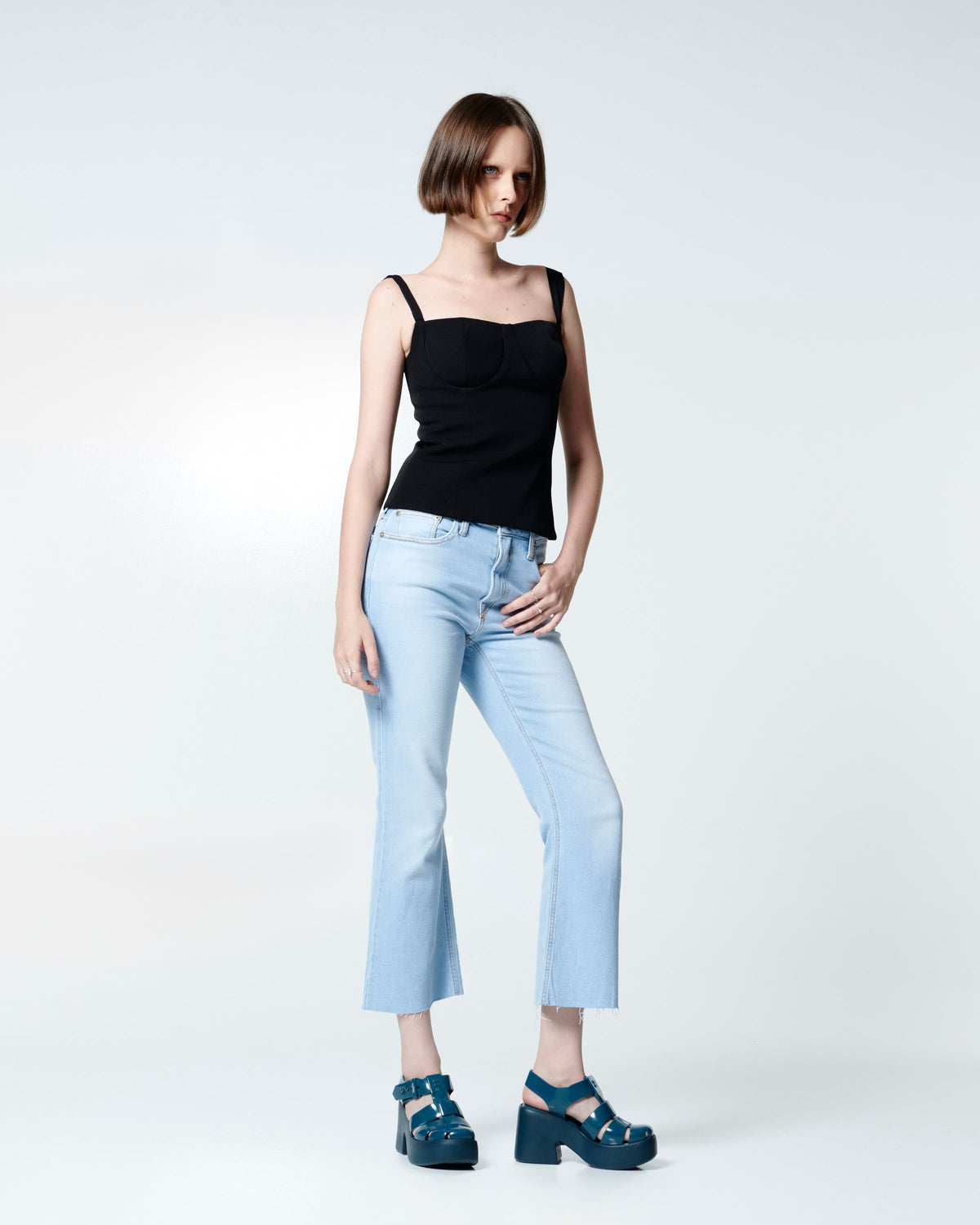 Model in an jeans and black tank top wearing a pair of blue Lulu platform heel fisherman sandals