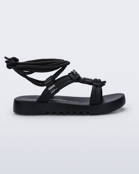 Side view of a black Kirk + Alexandre Pavao sandal with ankle strap