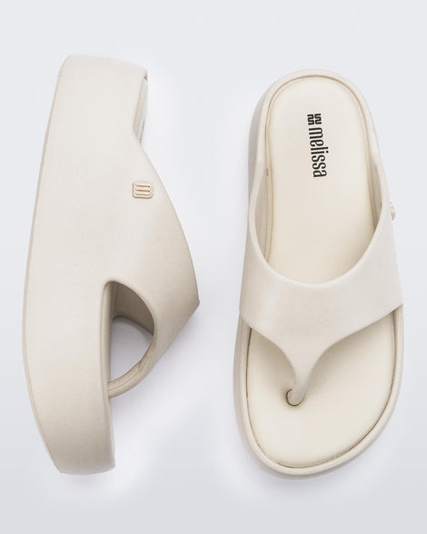 Side and angled view of a pair of beige Free Platform Thong sandal