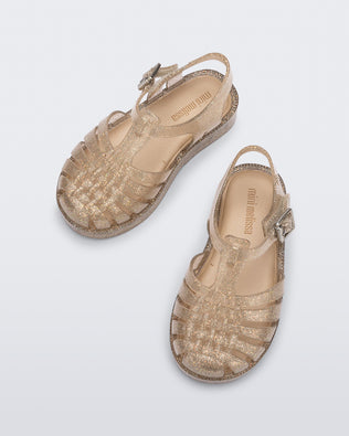 Top and side view of a pair of glitter beige baby Possession sandals