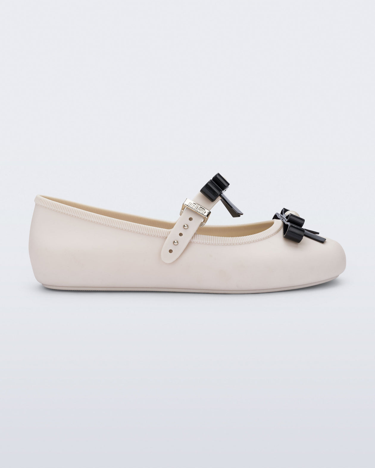 Side view of a beige Soft Ballerina Bow with black bows and a pearl in the center of each bow
