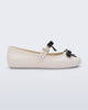Side view of a beige Soft Ballerina Bow with black bows and a pearl in the center of each bow