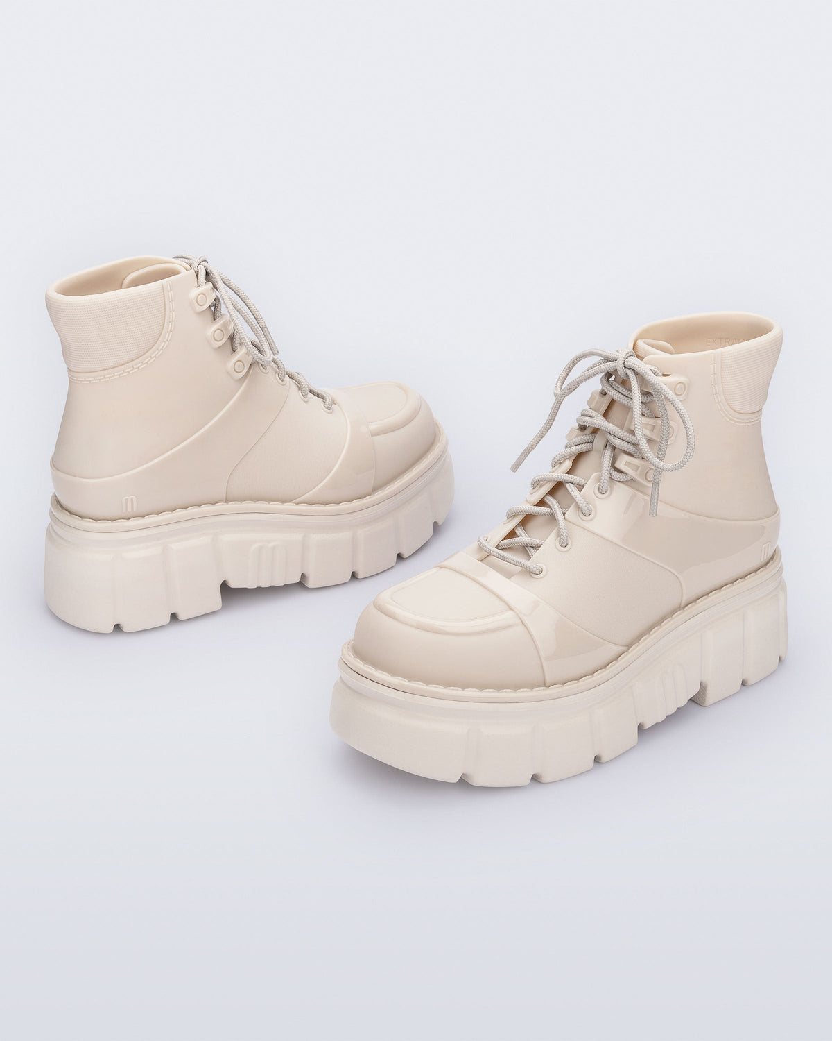 Back and side angled view of a pair of beige Rebel Boots with laces