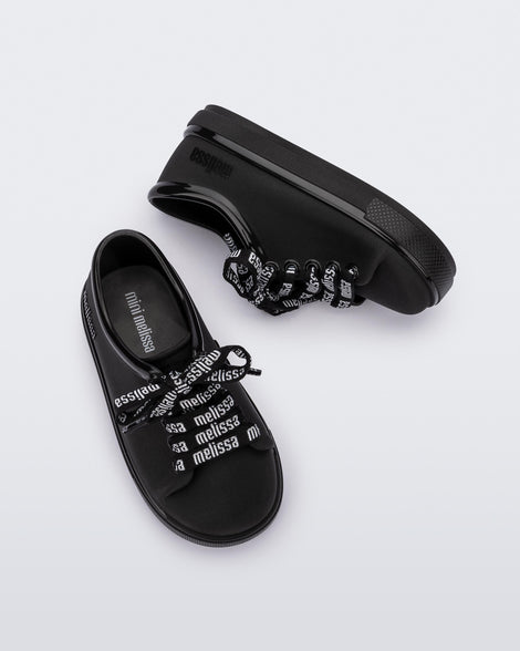 Top and side view of a pair of black baby Hip M Lover sneakers with laces