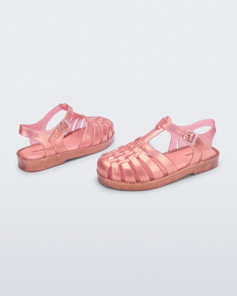 Top and angled view of a pair of pearly pink kids Possession sandals