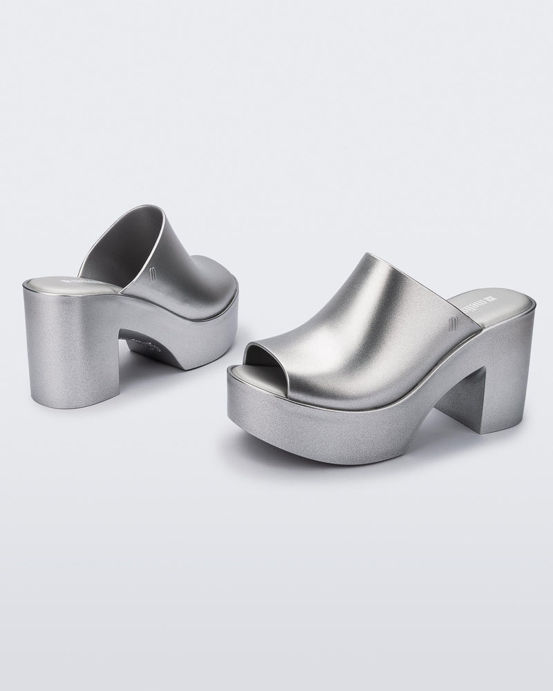 Angled view of a pair of light silver Mule Hype Platforms