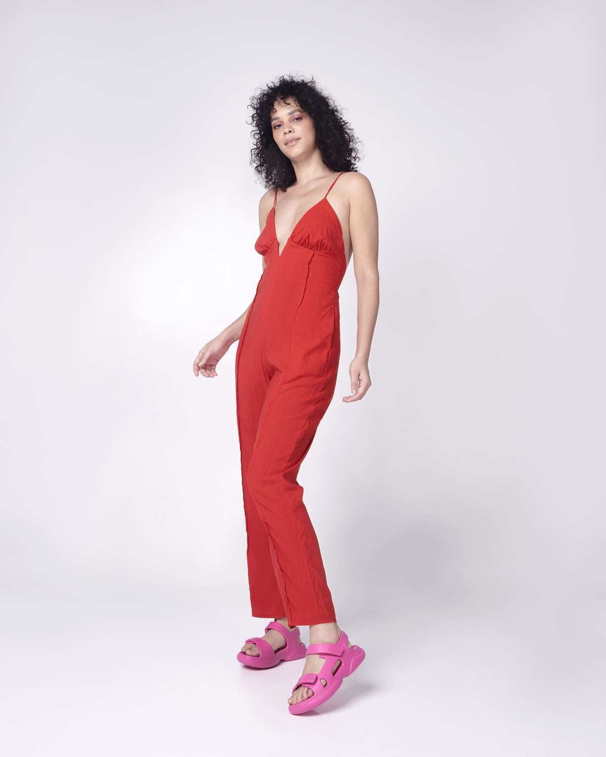 Model in a red outfit wearing a pair of pink Free Papete sandals.