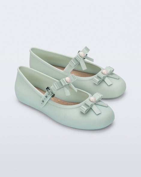 Angled view of a pair of green Soft Ballerina Bow flats with bows and a pearl in the center of each bow