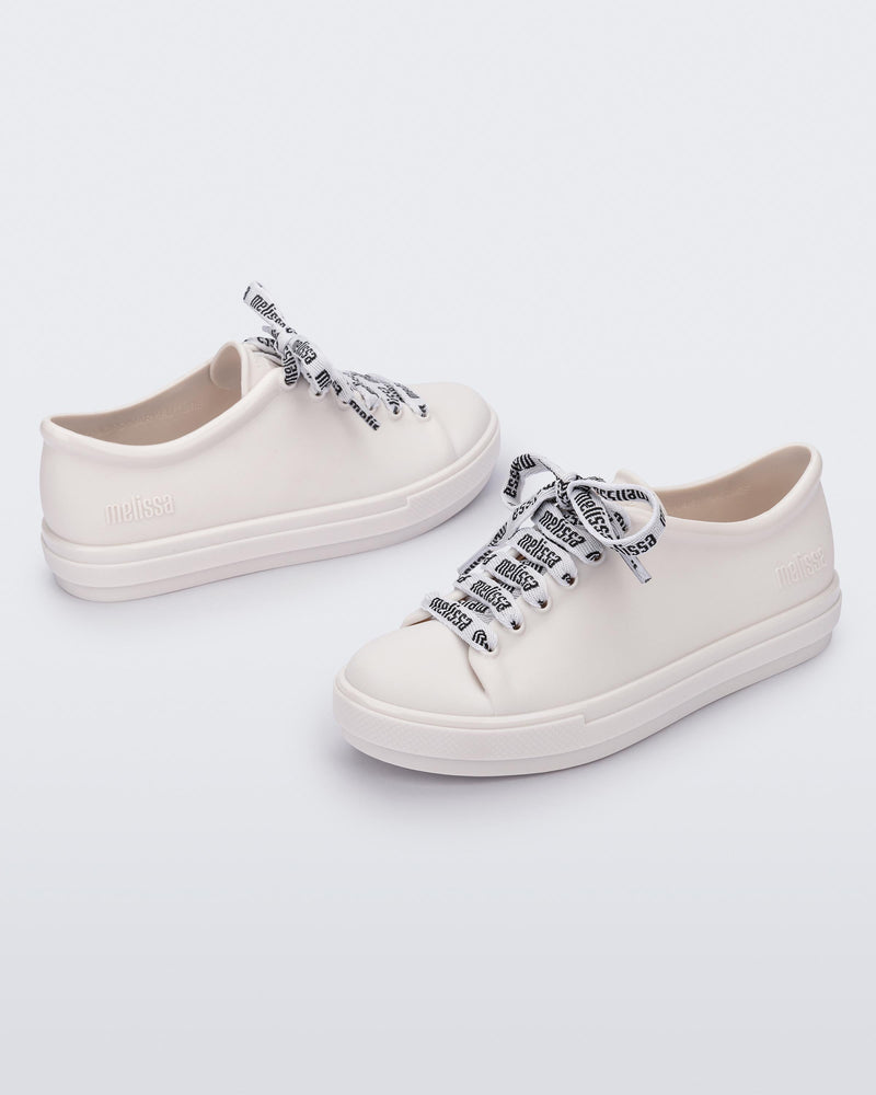 Angled view of a pair of white Hip M Lover kids sneakers with laces.