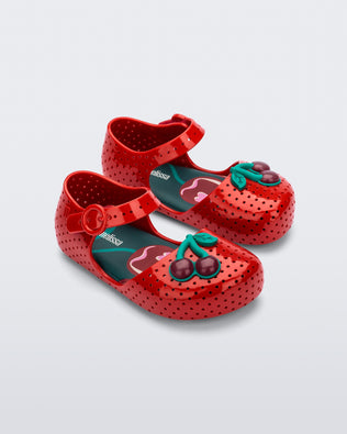 Angled view of a pair of red Pop baby flats with two dark red cherries