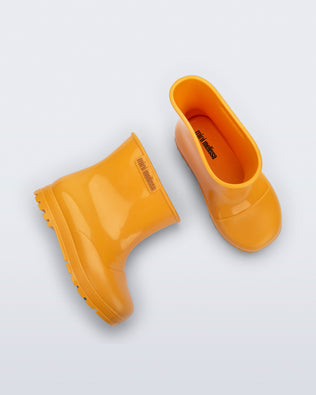Top and side view of a pair of orange Welly baby rainboots