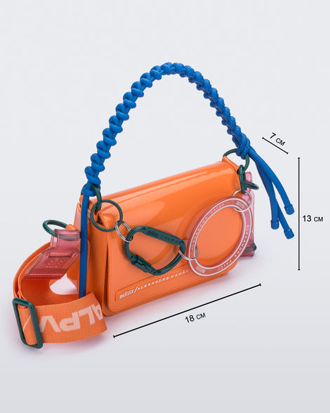 Angled view of an orange Olga Bag + Alexandre Pavao with blue short strap fabric long  strap. With purse dimensions of 18cm x 7cm x 13cm