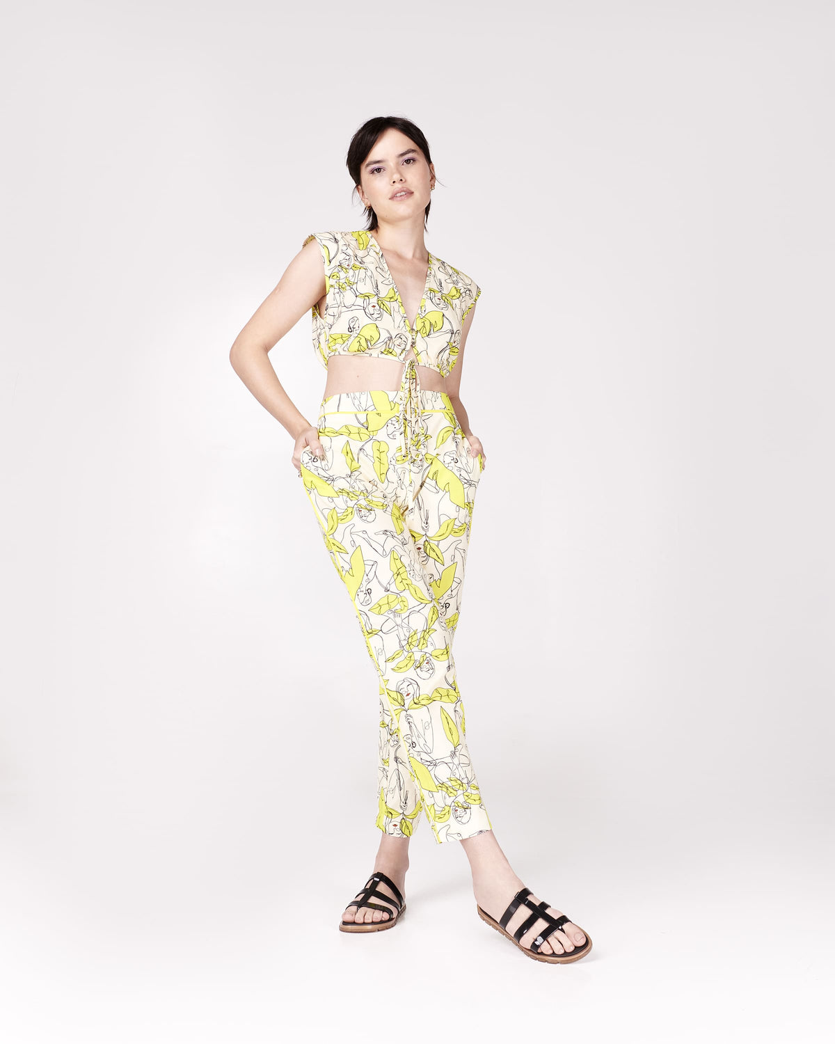 Model wearing a pair of black Path adult sandals with  gold sole