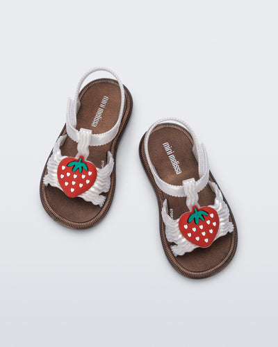 Top view of a pair of pearly white baby Hip Sandals with red strawberry